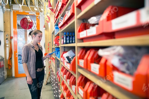 Preview: Young woman in storeroom of a bicycle repair shop