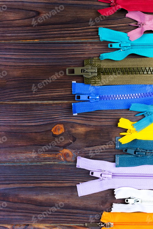 Preview: different colorful zippers in front of wood background
