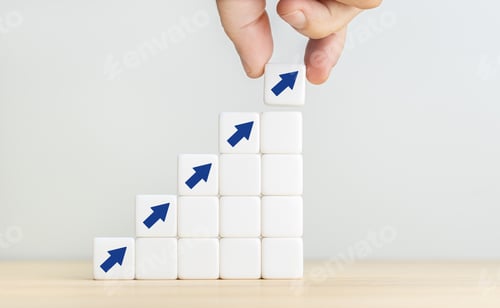 Preview: Human hand placing a cube with up arrow on top of other stacked blocks