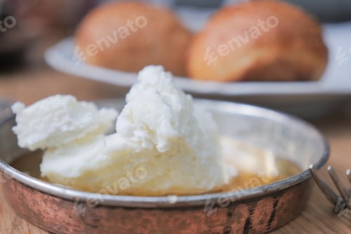 Preview: butter cream and honey in a bowl on table .