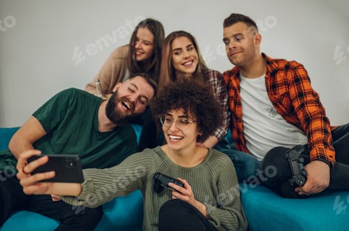 Preview: Friends having fun at home and taking selfie with a smartphone