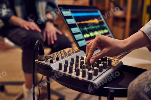 Preview: Hand of young female adjusting sound whil.e recording music