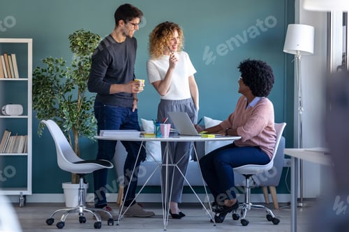 Preview: Casual young business people working and talking of they new project together in the office.