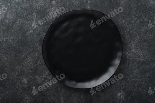 Preview: Ceramic empty black plate on old black ceramic cement concrete table background. Cooking stone backd