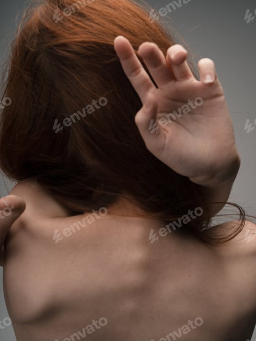 Preview: Nude woman touches herself with hands on a light background model cropped view