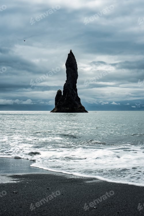 Preview: Moody Reynisdragar natural rock formation on Reynisfjara black sand beach in Atlantic ocean