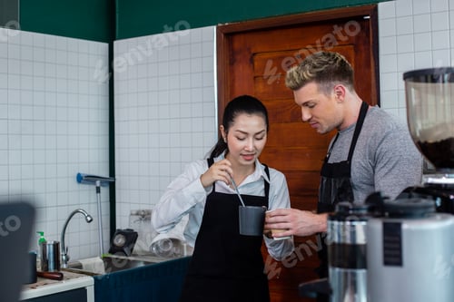Preview: Barista wearing apron talking test new flavour coffee with store women manager in counter at coffee