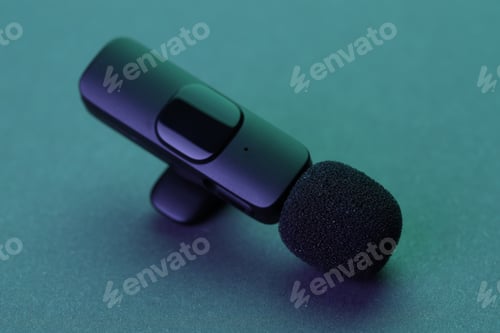 Preview: Lavalier microphone on dark table in neon lights, closeup
