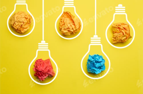Preview: Crumpled balls of paper inside an electric lamp on a yellow background. Concept of new ideas