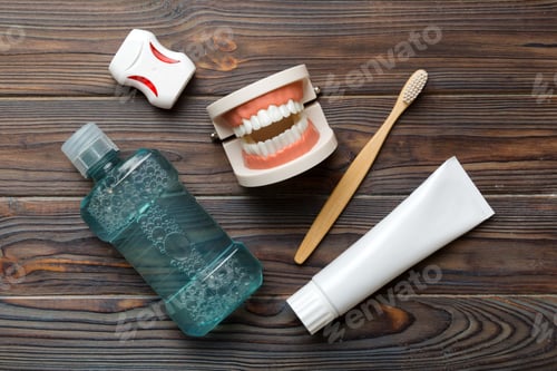 Preview: Mouthwash and other oral hygiene products on colored table top view with copy space