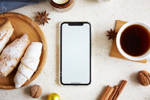 Preview: Mock up phone screen among Christmas crescent handmade bagels with cinnamon sticks