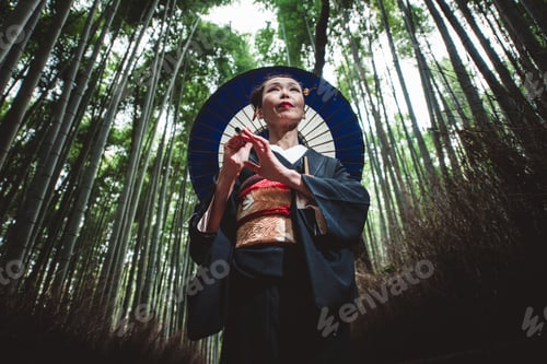 Preview: Beautiful japanese senior woman walking in the bamboo forest