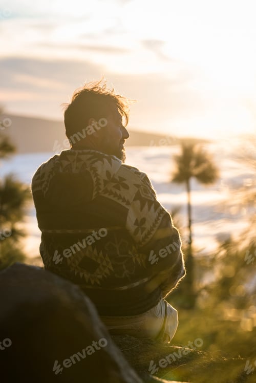 Preview: One man have relax sitting on the cliff looking clouds in background - concept of travel people