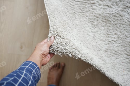 Preview: men hand rolling out new rug.