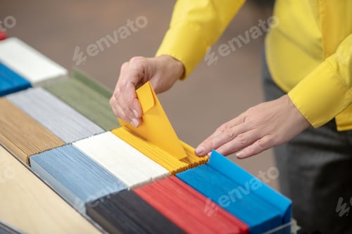Preview: Female hands taking out yellow envelope from the selection