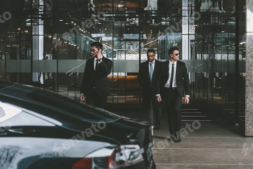 Preview: businessman and two bodyguards walking to auto