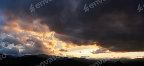 Preview: Dramatic sunset scene with dark, brooding clouds casting shadows over sky.