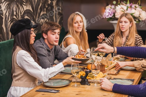 Preview: Group of friends at a dinner party eating spicy potatoes