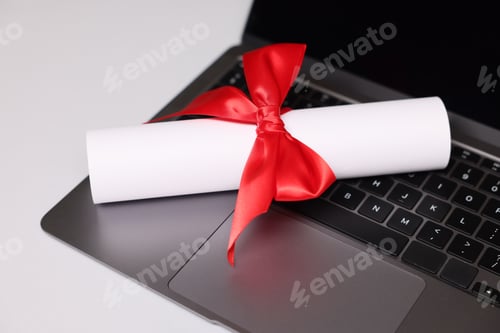 Preview: Diploma and laptop on light table, closeup