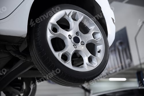 Preview: Car on lift at tire service, closeup
