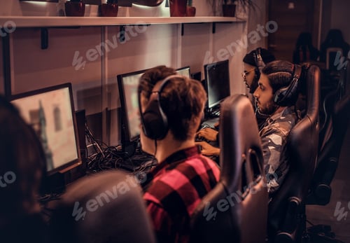 Preview: Team of teenage gamers plays in a multiplayer video game on pc in a gaming club.