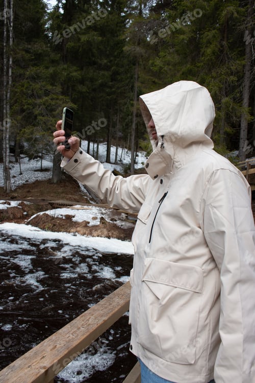 Preview: A young man takes pictures of a beautiful forest on his phone