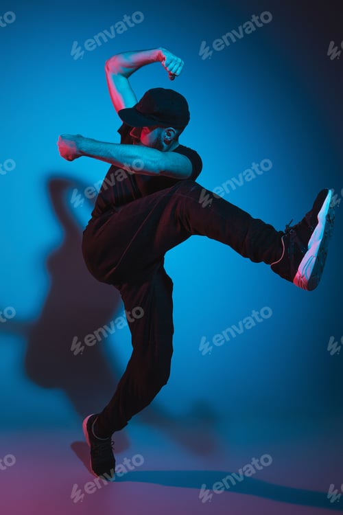 Preview: The silhouette of one hip hop male break dancer dancing on colorful background
