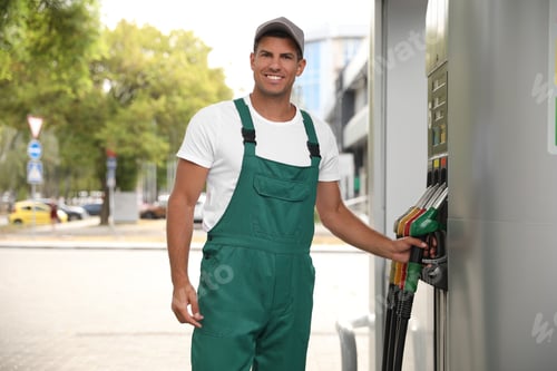 Preview: Worker taking fuel pump nozzle at modern gas station