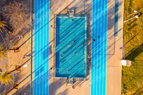 Preview: Aerial view of the city public basketball and football court with running track.