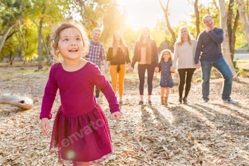 Preview: Mixed Race Baby Girl Outdoors with Family Behind