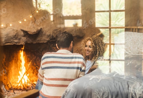 Preview: One couple man and woman enjoy leisure indoor activity sitting in front of a warm fireplace