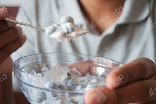 Preview: men eating yogurt with blue berry in a bowl