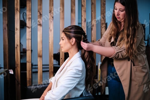 Preview: Hairstylist doing a hairstyle for a bride for her wedding day at the hair salon.