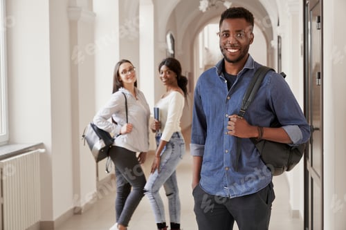Preview: African student wearing blue shirt holding notes