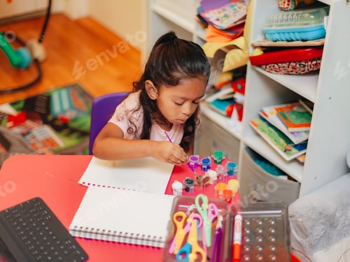 Preview: Diverse pre school girl at home learning to paint by following tutorial on tablet device