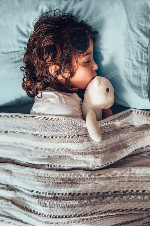 Preview: little girl sleeping in bed with her teddy bear