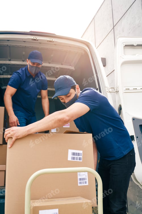 Preview: Two couriers in protective masks unloading packages
