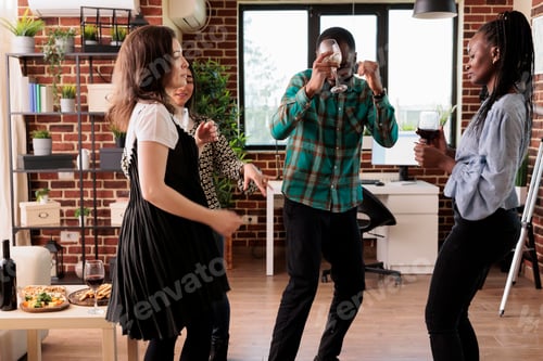 Preview: Cheerful people in living room at home enjoying wine party while drinking and having fun.