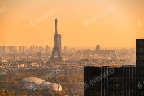 Preview: Sunrise over Paris with a hazy view of the Eiffel Tower and modern buildings of Louis Vuitton