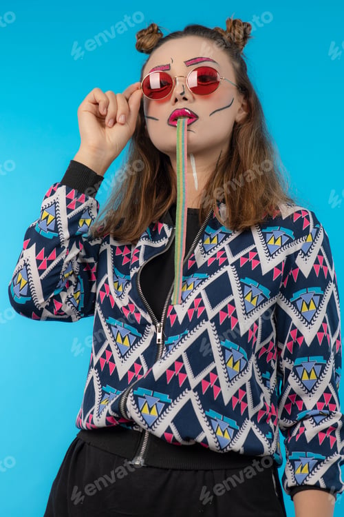 Preview: Young creative girl with sweet candy on blue background