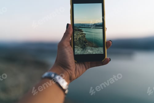 Preview: Anonymous person taking photo of sea and nature