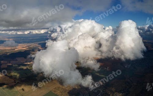 Preview: Aerial view from airplane window at high altitude of earth covered with white puffy cumulus clouds