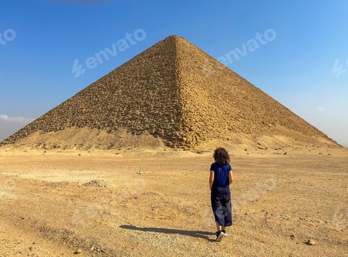 Preview: Woman from behind walking by the desert to the Red Pyramid in Dahshur, Egypt