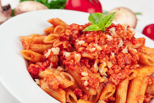Preview: Pasta with meat, tomato sauce and vegetables on the table