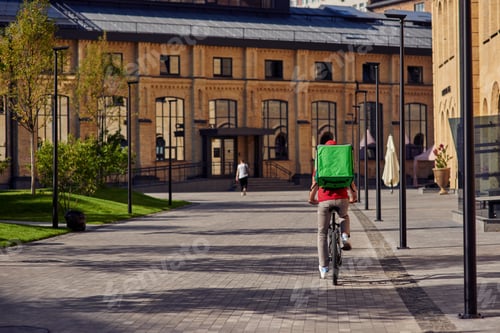Preview: Courier on bicycle riding along beautiful sunny street