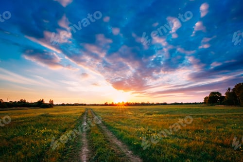 Preview: Sunset, Sunrise Over Rural Field Meadow. Bright Dramatic Sky And