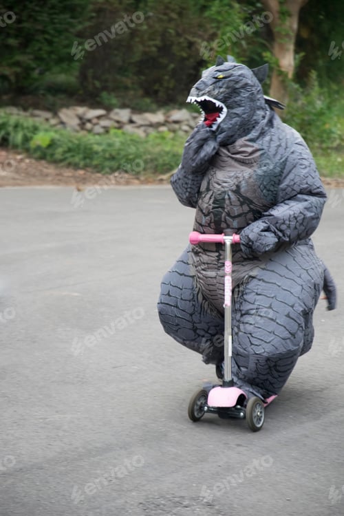Preview: Child in a Godzilla Costume Riding a Scooter
