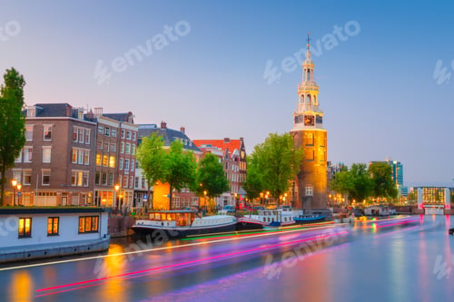 Preview: Montelbaan tower, Amsterdam, Netherlands. Evening cityscape. Dark sky and city lights.
