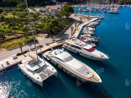 Preview: Scenic aerial view many yachts boats moored at Croatian bay harbor shore blue turquoise clear water