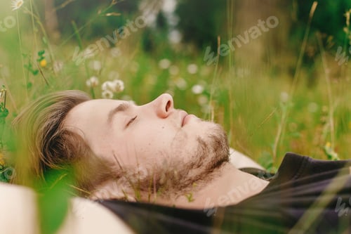 Preview: Stylish hipster man lying on sunny grass